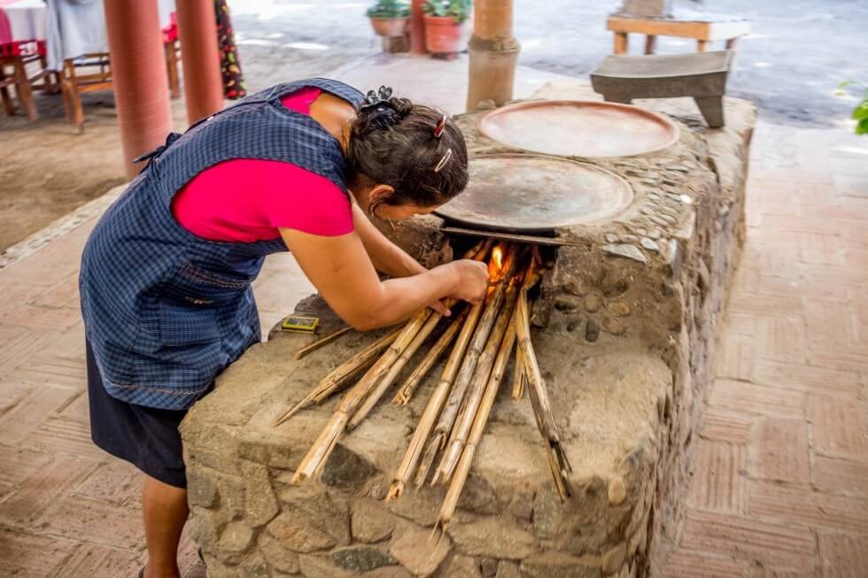 Lighting the fire under the comal Oaxaca Cooking Classes