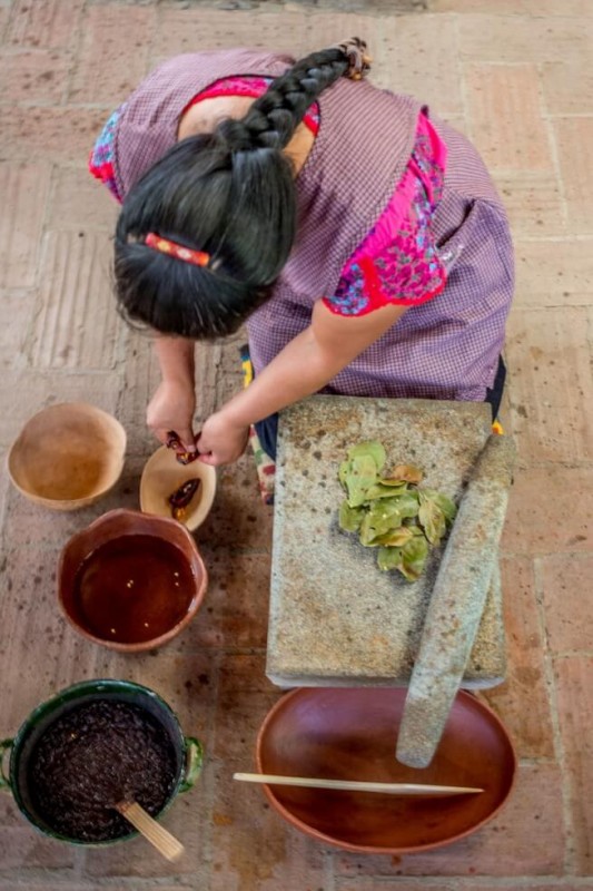 Reyna demonstrating the metate Oaxaca Cooking Classes