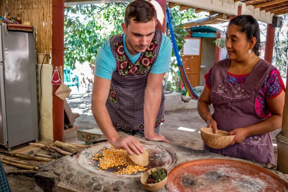 Tom roasting corn on the comal Oaxaca Cooking Classes